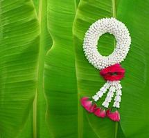 Handmade jasmine garland, a symbol of Mother's Day in Thailand. on banana leaf background photo