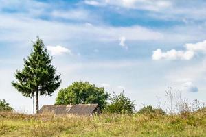 Beautiful old abandoned building farm house in countryside on natural background photo