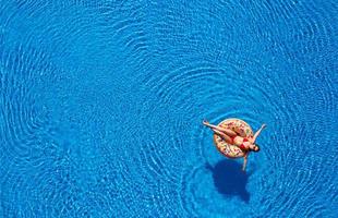 Woman floating on the pool photo