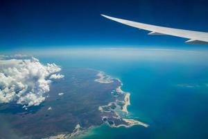 Clouds and sky as seen through window of an aircraft. Fly above the top end of Australia, Northern territory state of Australia. photo