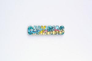 Colourful PVC souvenir fridge magnet of Canary Islands on white background. Travel memory concept. Gift typical product for tourists from foreign trip. Home decoration. Top view, flat lay, close up photo