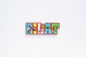 Colourful PVC souvenir fridge magnet of Eilat, Israel on white background. Travel memory concept. Gift typical product for tourists from foreign trip. Home decoration. Top view, flat lay, close up photo