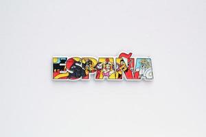 Colourful PVC souvenir fridge magnet of Spain on white background. Travel memory concept. Gift typical product for tourists from foreign trip. Home decoration. Top view, flat lay, close up photo