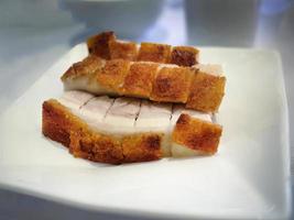 Selective focus, focus on foreground, close up, Crunchy, sliced of crispy roasted pork belly on white plate, Cantonese Style food, blurred background photo