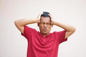 asiático hombre tiene un dolor de cabeza estrés desde trabajar. foto
