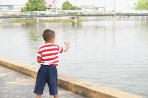 boy feeding fish in the park photo