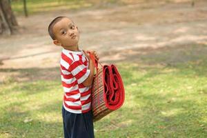 boy holding Mats for sitting in the garden photo