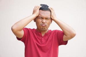 asiático hombre tiene un dolor de cabeza estrés desde trabajar. foto