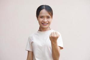 Asian woman clenching her fists confidently, delighted photo