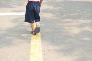 A boy running on the street in the park photo