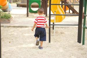 boy playing in the playground in the park photo