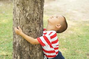 concept of saving the world boy hugging a tree photo