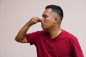 men pinch their noses with their hands to avoid foul odors. photo