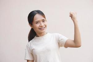 Asian woman clenching her fists confidently, delighted photo