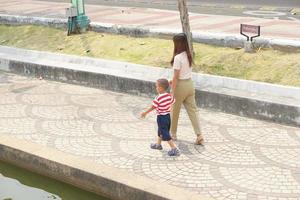 madre toma bebé para un caminar en el parque fiesta foto