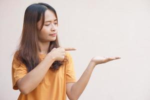 An Asian woman stretches her hand to the side like an empty object on her hand. photo