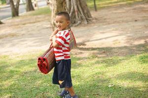 boy holding Mats for sitting in the garden photo