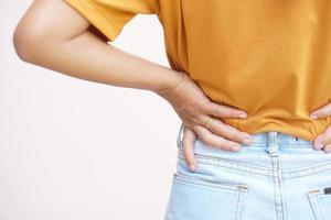 Asian woman having waist pain from working hard, lifting heavy things photo