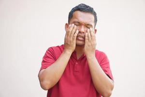 Asian man has eyestrain from looking at the computer photo