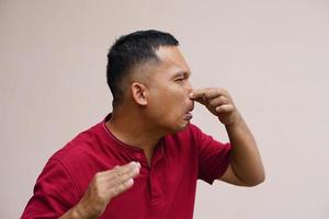 men pinch their noses with their hands to avoid foul odors. photo