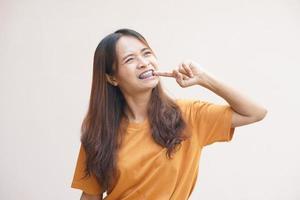 Asian woman picking food scraps from her teeth photo