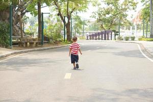 un chico corriendo en el calle en el parque foto