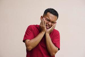 Asian man with toothache touches cheek with her hand photo