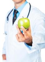 Doctor's hand holding a fresh green apple close-up on white photo