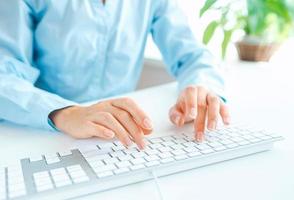 Woman office worker typing on the keyboard photo