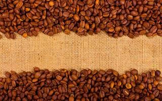 Coffee grains on the burlap background photo