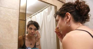 Woman In Front Of Mirror Applying Makeup video