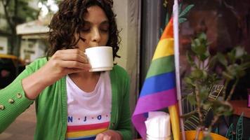 Young woman having a cup of coffee at LGBTQ bar video