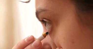 Woman In Front Of Mirror Applying Eye Mascara video