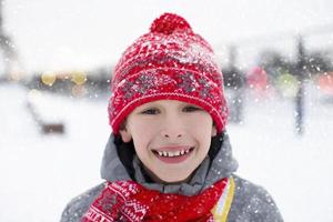 retrato de un contento pequeño chico en invierno, él es sonriente y mirando a el cámara. foto