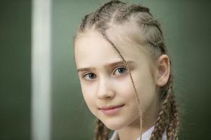Close-up portrait of a schoolgirl with pigtails. photo