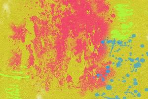 Pink and blue paint stains on yellow textured paper. photo