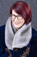 Portrait of an elegant middle-aged woman with glasses and red hair. photo