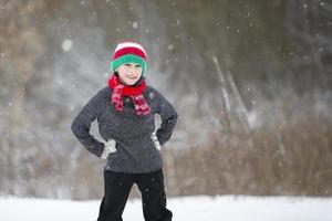 niño en invierno en el bosque. contento chico en un invierno día en el antecedentes de naturaleza foto