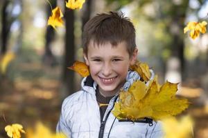 otoño retrato de un niño en otoño amarillo hojas.hermosas niño en el parque al aire libre, octubre temporada foto