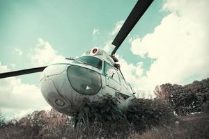 Vintage retro helicopter on the background of the emerald sky. photo