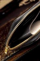 Leather wallet with a golden zipper close-up on a dark background. photo