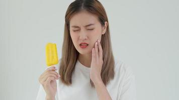 asiatisk kvinna känna känslig tänder efter äter is grädde, kvinna lida tand, förfall problem, dental vård, tand extraktion, förfall problem, dålig andetag, gingival lågkonjunktur, oral hygien instruktion video