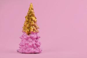 Christmas composition. Pink Christmas tree with gold on a pink background. Happy Holidays. minimal new year concept. photo