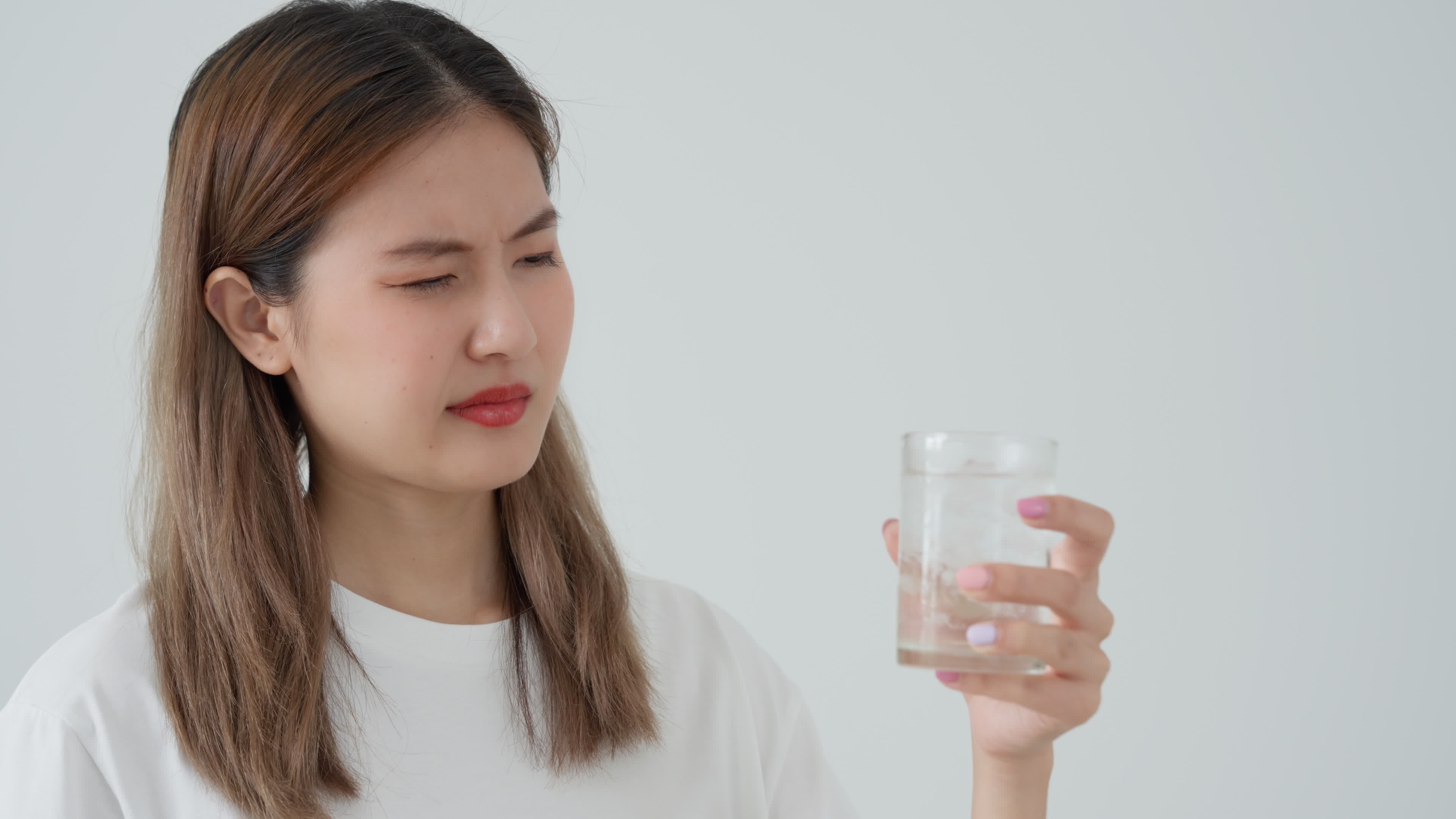 Asian woman feel sensitive teeth after drinking cold, female suffer