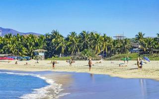 puerto escondido oaxaca mexico 2023 personas sombrillas Dom tumbonas playa olas palmas zicatela México. foto