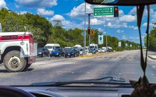 Playa del Carmen Quintana Roo Mexico 2022 Driving traffic jam on road street highway through jungle nature. photo