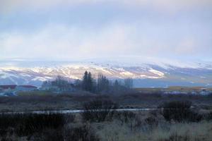 islandés paisaje con nieve cubierto montañas y nubes en invierno. foto