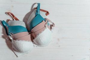 Set of colorful bra on wooden background, closeup. photo
