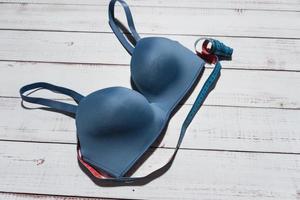 Blue bra on wooden background, closeup. Womens underwear. Top view. photo