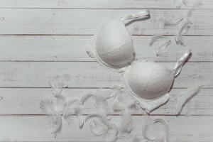 White lace bra on wooden background, closeup photo